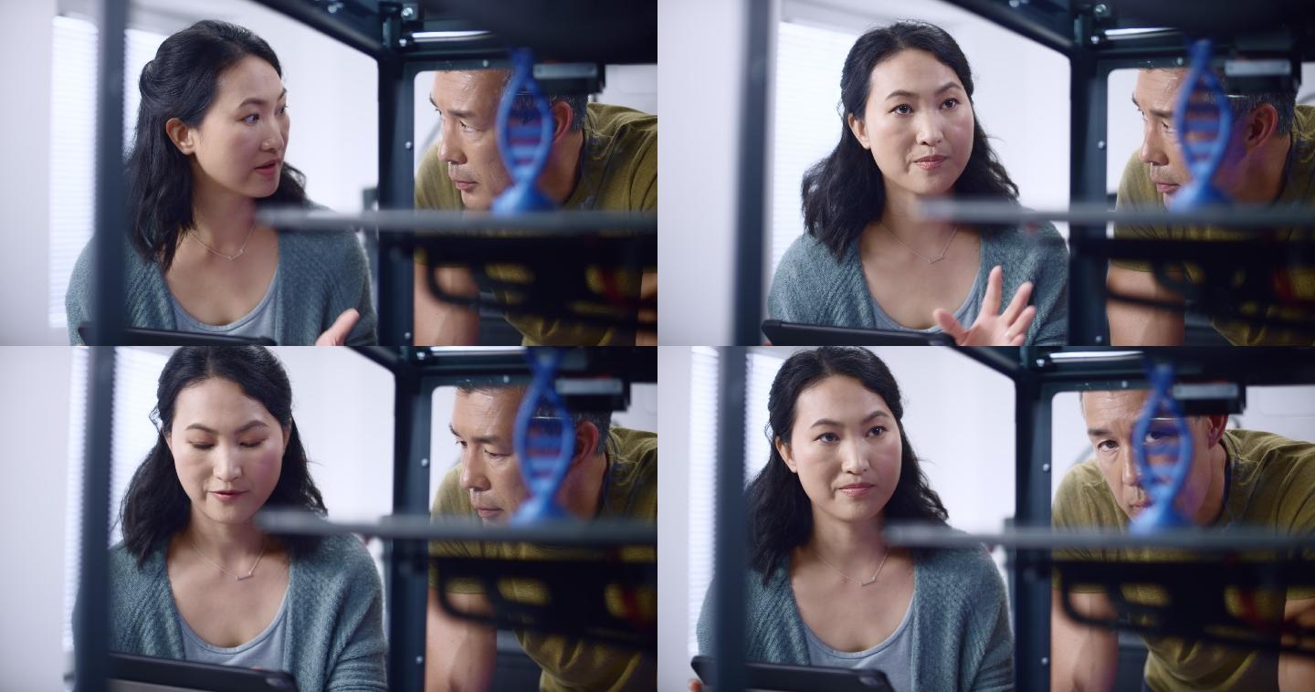 亚洲女工程师和她的亚洲男同事讨论在3D打印机中构建双螺旋模型