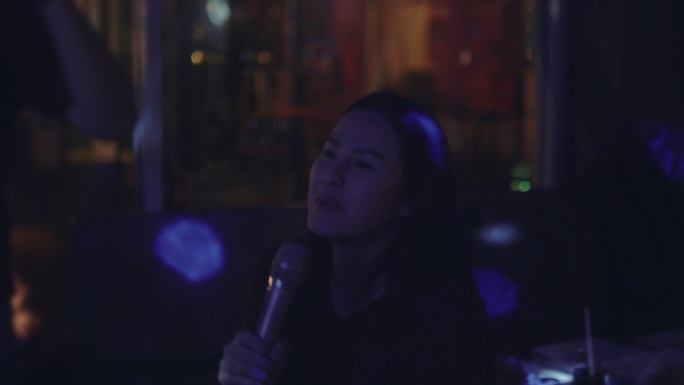 亚洲女性朋友团在卡拉OK唱歌和微笑