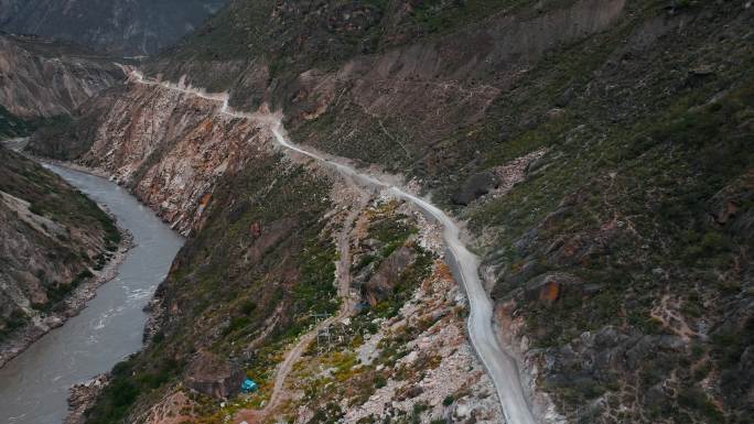 滇藏线丙察察艰险狭窄的沿江环山道路土路