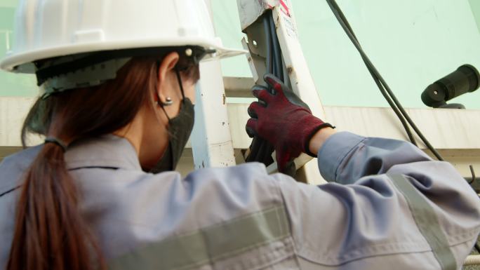 亚洲女技术员检查员检查电力电缆线路。肩后摄像头