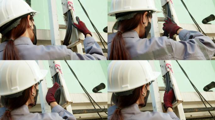 亚洲女技术员检查员检查电力电缆线路。肩后摄像头