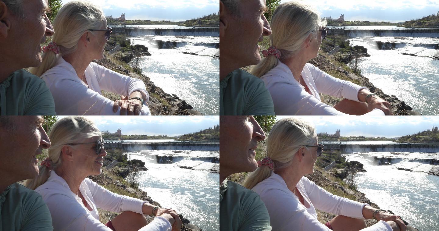 成年夫妇在河流和水电站大坝上方放松