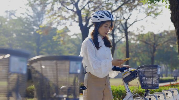 亚洲女商人在市中心租用共用自行车上班