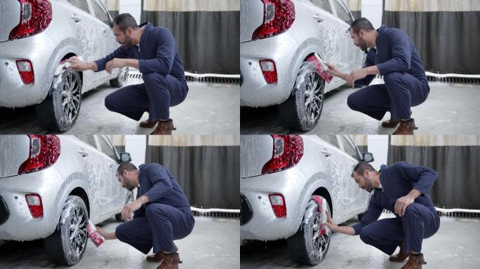 拉丁美洲蓝领工人在一家汽车修理店用肥皂扫帚清洁汽车轮胎