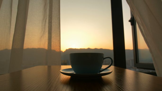 日出背景下桌上的咖啡杯