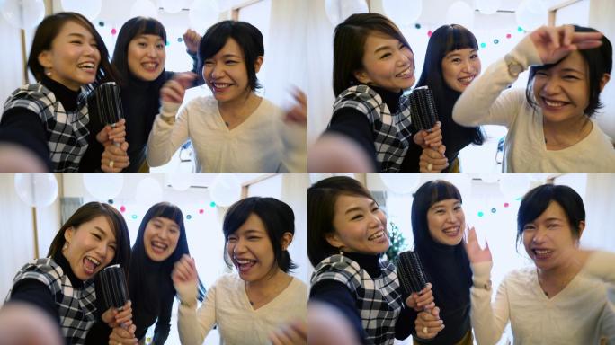 三名年轻日本女性在家唱卡拉OK时的电话视频