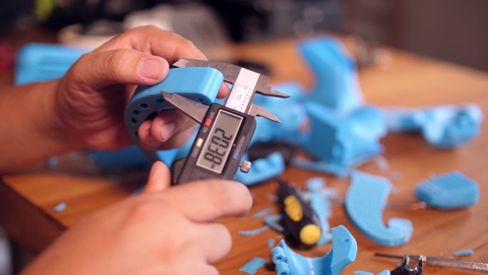 工人使用游标卡尺测量3D打印零件的比例