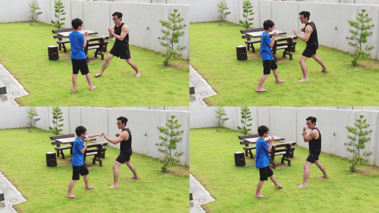 亚洲华人父亲运动员在花园训练儿子跆拳道。泰拳、武术