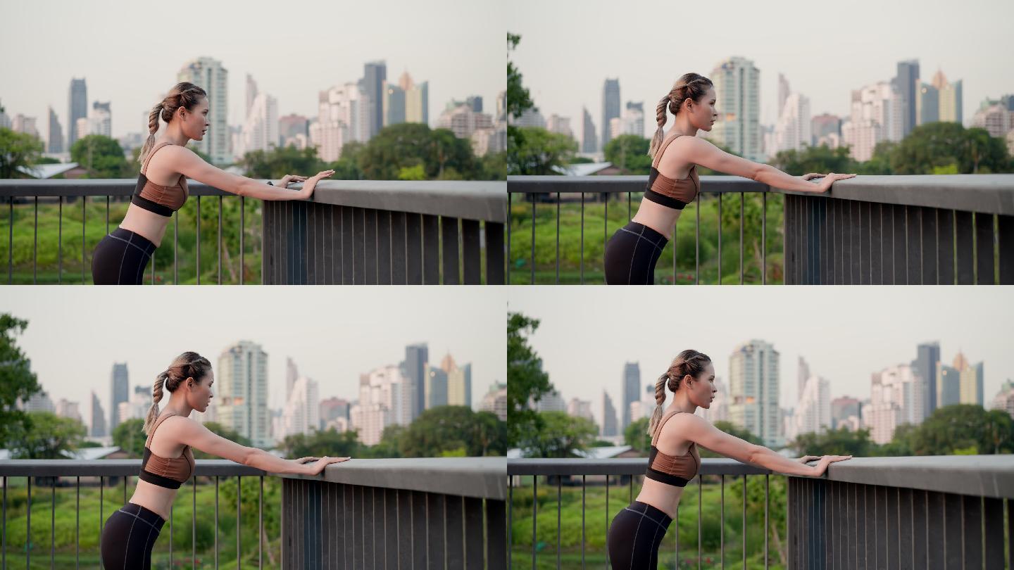 亚洲美丽的中年女性，穿着运动装，在护栏上、在城市公园的人行天桥上进行完美的肌肉推高运动，健康的生活方