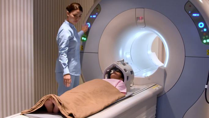 小女孩躺下准备核磁共振扫描
