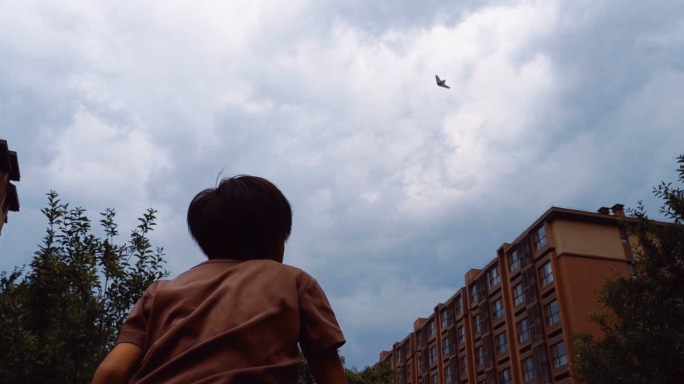 孩子向天空扔纸飞机