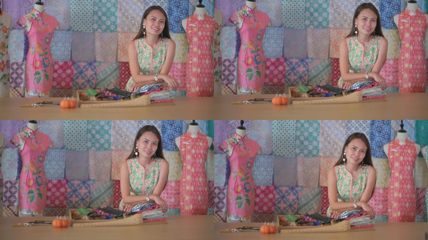马来西亚华裔美女精品店小企业主画像在她的蜡染旗袍面料纺织品零售店前微笑着看着相机