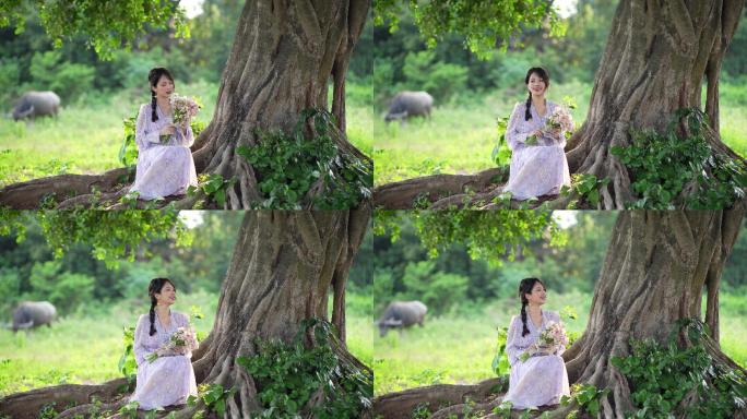 女孩拿着花束在榕树下