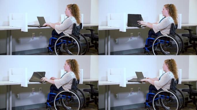 坐在轮椅上在办公室使用笔记本电脑的女性