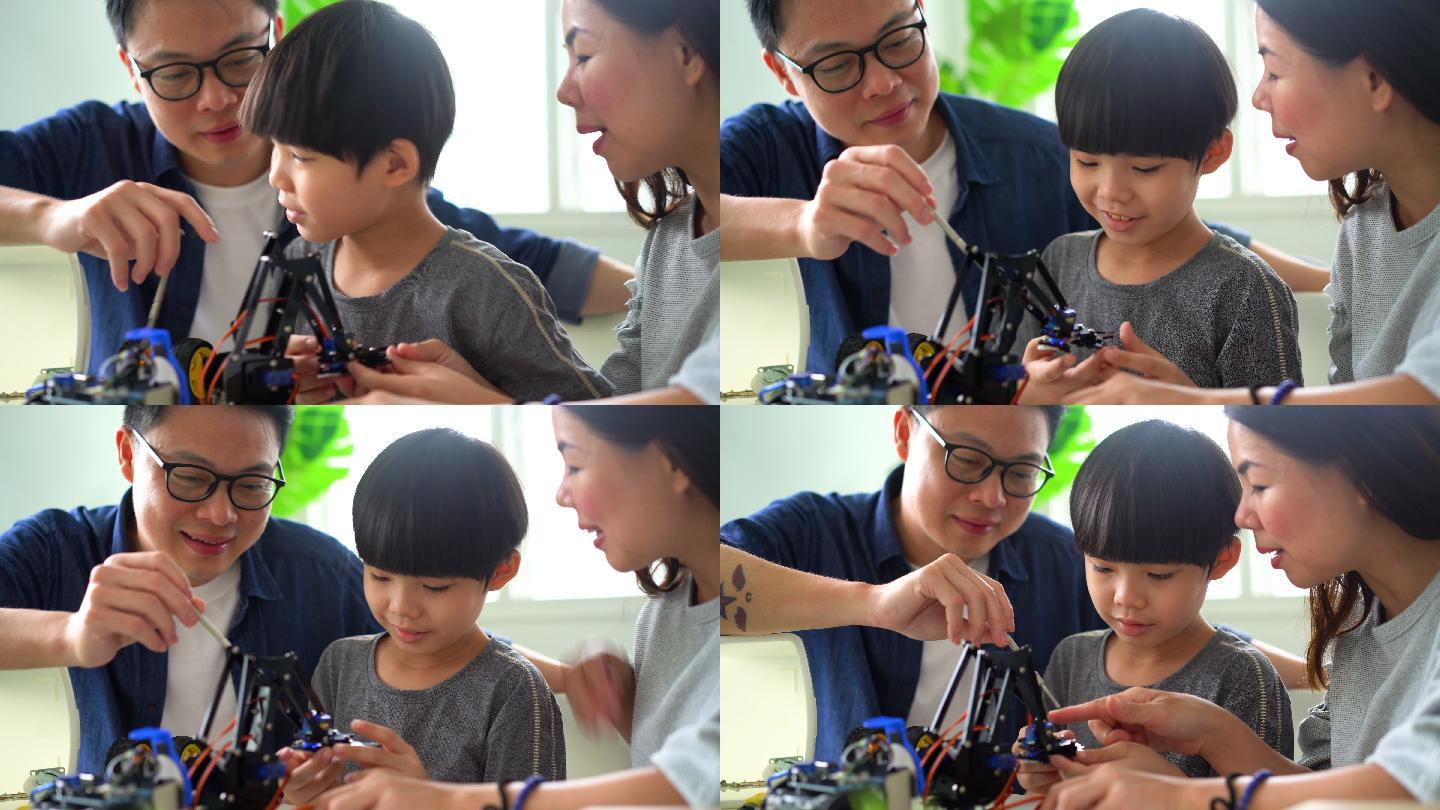 亚洲小男孩与父母一起制作机器人玩具