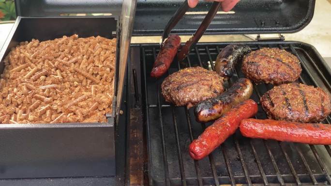 后院烧烤使用户外木屑烤架，在夏天烤焦烤汉堡、焦烤腊肠、焦烤热狗