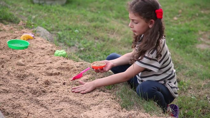 小女孩在公园里玩沙子