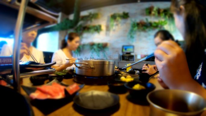 一群十几岁的亚洲人在台湾购物中心吃着涮涮涮锅，这是都市人的生活方式