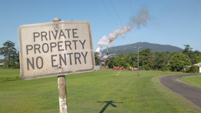 昆士兰北部热带地区一家糖厂烟囱造成的空气污染旁的私人财产标志