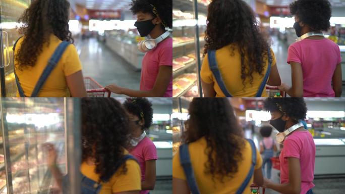 母亲和女儿一起在超市购物-戴口罩