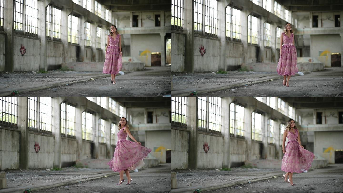 废弃仓库中穿着粉红色连衣裙的年轻女士