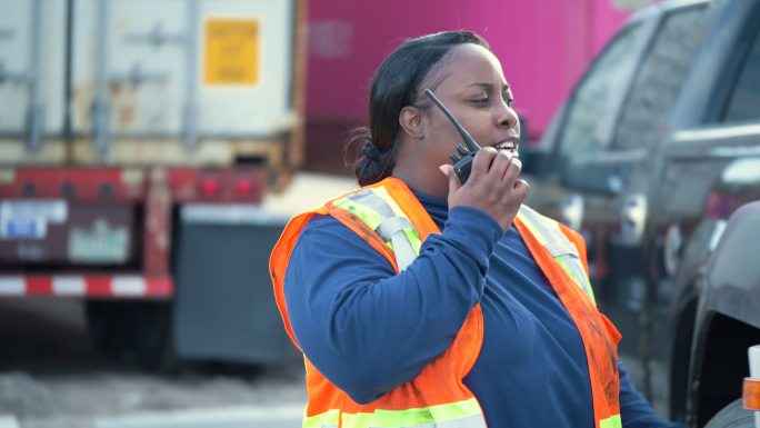 货运设施的女性卡车司机使用对讲机