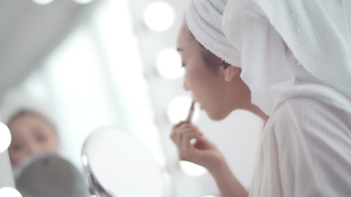 年轻女性在镜子前化妆