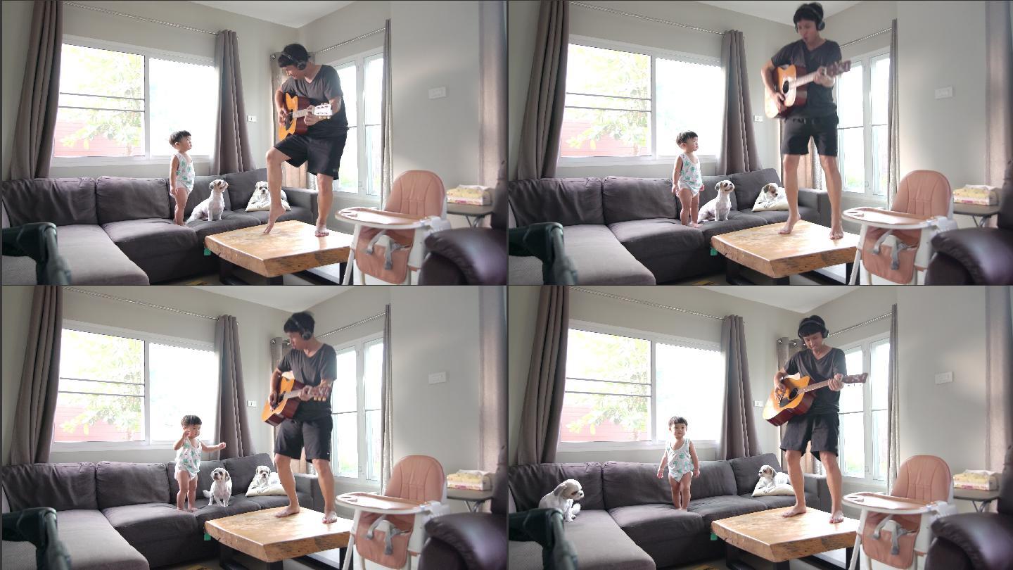 快乐的父亲在家的客厅里和一个儿子和两只狗弹吉他。