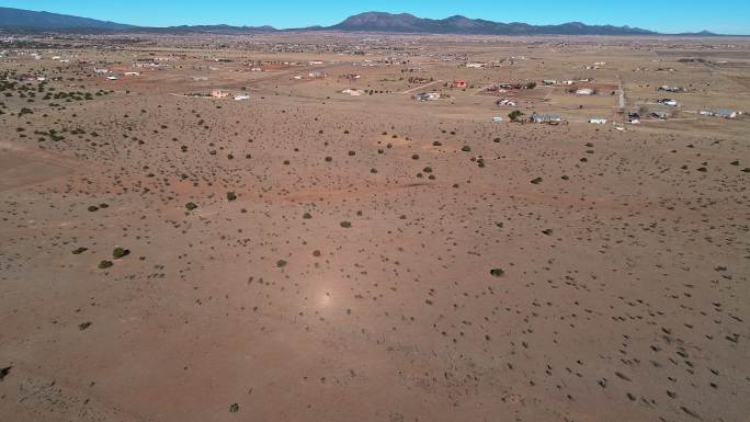新墨西哥州埃奇伍德附近沙漠中的农场和牧场，沿着40号公路。具有后置摄像头运动的无人机视频