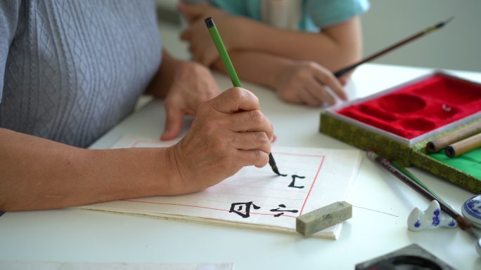 亚洲资深女子在家教孙子中国传统书法