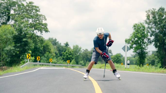 他在室外公路上玩直列冰球滚轴溜冰。