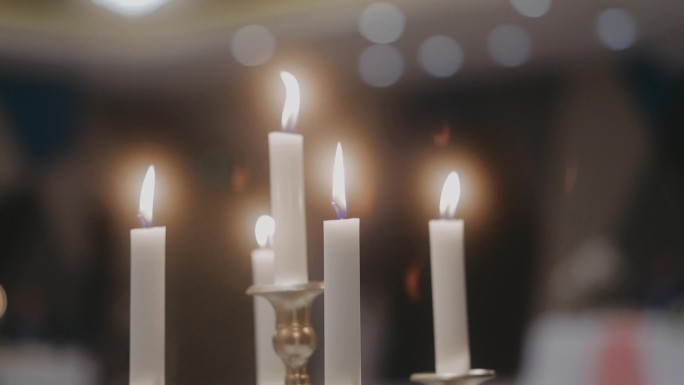 美丽的白色蜡烛和背景散焦的烛台