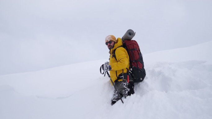 冬天背着背包在山上徒步旅行的男人