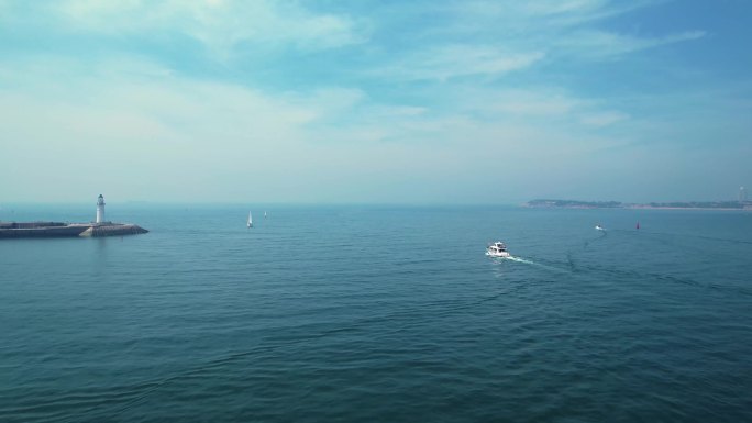 航拍游艇出航蔚蓝色大海灯塔
