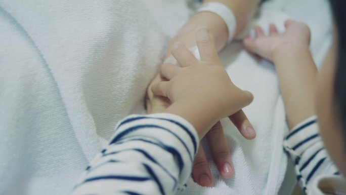 孕妇在医院与孩子牵手。