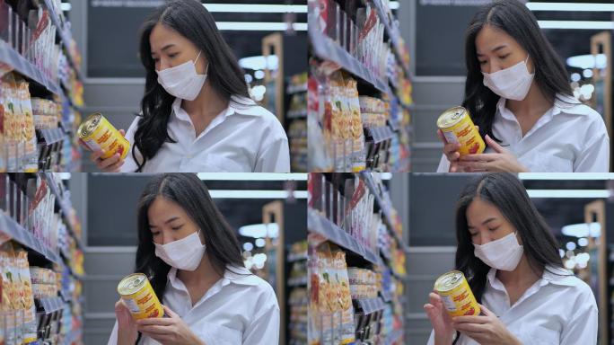 在冠状病毒疫情期间，25岁的亚洲年轻女性戴着医用防护面具在超市购买基本必需品。杂货店购物概念。