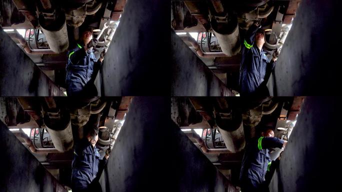 亚裔中国机械师在修理厂使用扳手卡车底盘进行检查和调整