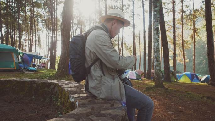 亚洲男人独自背包旅行。男旅游摄影师休息吃饭