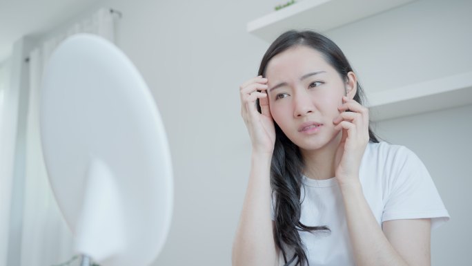 亚洲女性担心晒伤导致的面部红肿、皮肤敏感、对类固醇过敏、面部皮疹。皮肤问题概念。