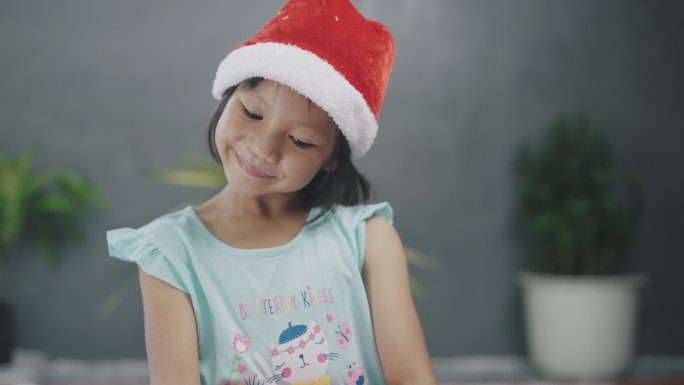 戴着圣诞老人帽子的小女孩得到了空的礼盒。
