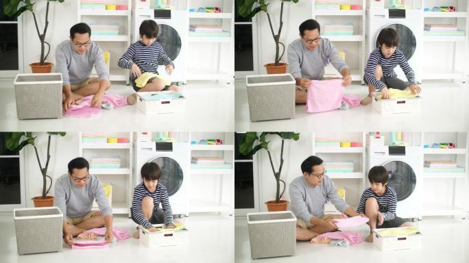 亚洲爸爸和儿子一起在家洗衣服，家庭家务一起做