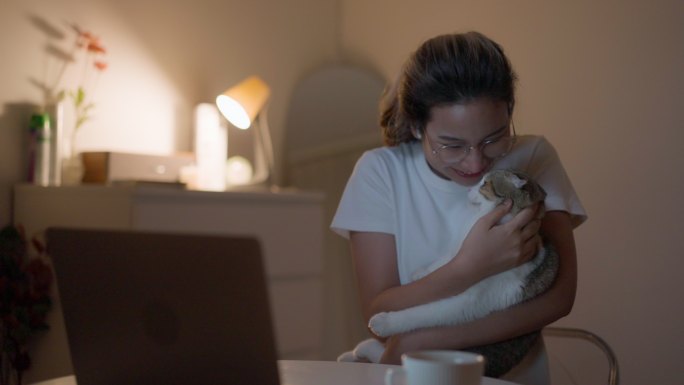年轻女子通过视频通话向朋友展示她的猫