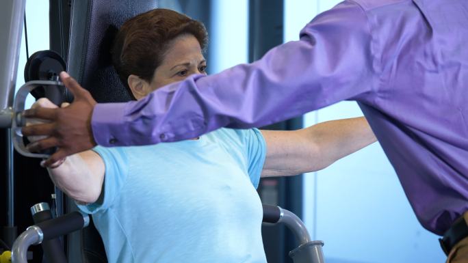 物理治疗师帮助老年女性锻炼上身