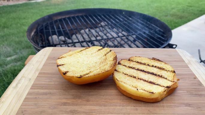 夏季后院烧烤时，带烧烤标记的奶油面包被扔在木制砧板上