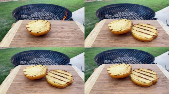 夏季后院烧烤时，带烧烤标记的奶油面包被扔在木制砧板上