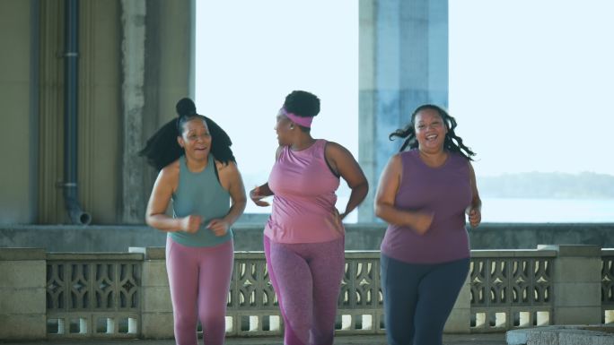 三名多种族女性在城市滨水区跑步