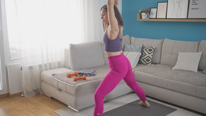 女运动员在家锻炼时伸展双腿