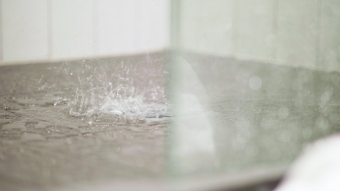 在瓷砖淋浴地板上泼水