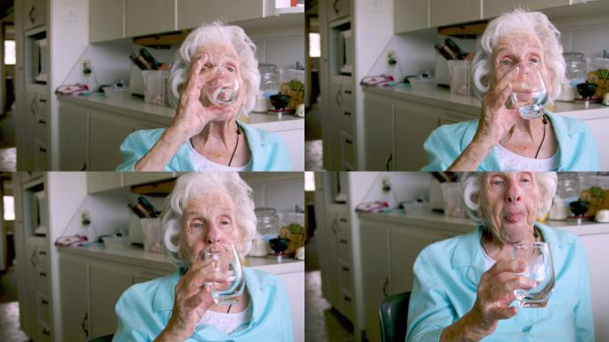 一位上了年纪的妇女在喝完橘子粉混合饮料后，整理并放下玻璃杯，以补充日常维生素或药物
