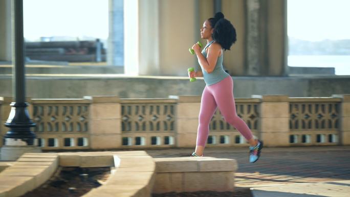 非裔美国女子在城市桥下奔跑